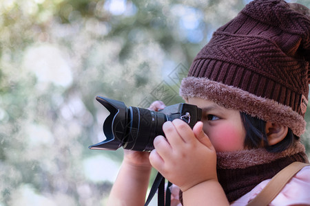 孩子一个穿着Woolhat的可爱小女孩肖像在天气下用数码摄影机拍照时脸色模糊而寒冷摄影概念冬天复古的图片