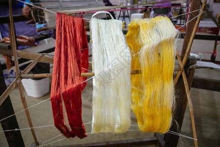 泰国当地多彩的传统丝线泰国手工制作的老式木条纹袖子轮旋转时装服用天然原材料在泰国手制的旧木线纹织圆形轮上旋转刺绣经济纤维图片