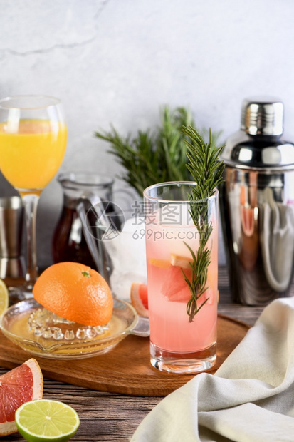 庆典冷藏酒鬼在柑橘水果和饮料的桌上加玫瑰和石榴的金鸡尾酒图片