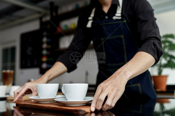 机器马克杯泰国咖啡店制造商手持机上的有选择焦点白咖啡杯因图片