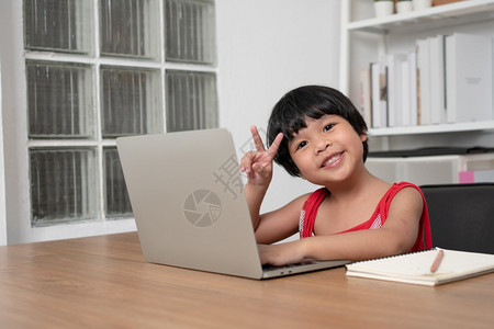 数字的亚洲快乐女学生在计算机上从教师电脑学习的幸福亚洲女孩在线学习班教育是一种以新的正常生活方式家庭学校概念和教为社会距离的技术图片