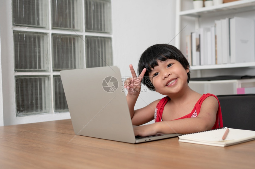 数字的亚洲快乐女学生在计算机上从教师电脑学习的幸福亚洲女孩在线学习班教育是一种以新的正常生活方式家庭学校概念和教为社会距离的技术图片