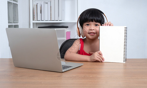 桌子亚洲快乐女学生在计算机上从教师电脑学习的幸福亚洲女孩在线学习班教育是一种以新的正常生活方式家庭学校概念和教为社会距离的技术校图片