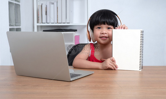 桌子亚洲快乐女学生在计算机上从教师电脑学习的幸福亚洲女孩在线学习班教育是一种以新的正常生活方式家庭学校概念和教为社会距离的技术校图片