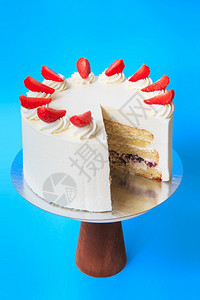 在木蛋糕摊上剪切的生日蛋糕美丽的白海绵蛋糕配奶油和草莓蓝背景复制空间食物摄影作为谱巧克力分层的派对图片