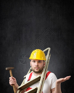 笨手脚的工人拿着梯子和铁锤站立着对一个手持工具的笨脚工人画像在职你自己难图片