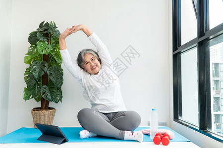 理疗瑜伽居家看视频锻炼的中年女性背景