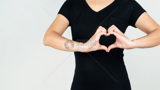 希望世界心脏日概念女人用手指在胸前的表达她爱做一个心手势女正面图片
