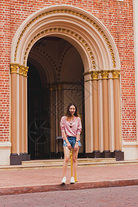 常设人们该妇女站在曼谷教堂入口旁是一个受欢迎的旅游胜地该妇女站在曼谷教堂入口旁图片