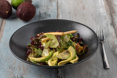 餐厅在木制桌子上黑碗中新鲜制作的Avocado沙拉吃无肉图片
