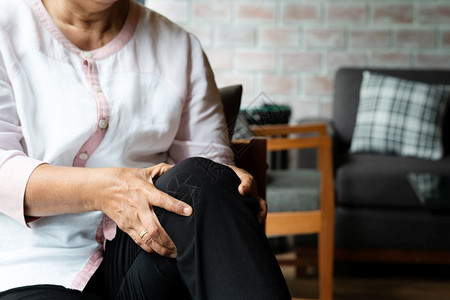 家中膝关节疼痛的老年妇女图片
