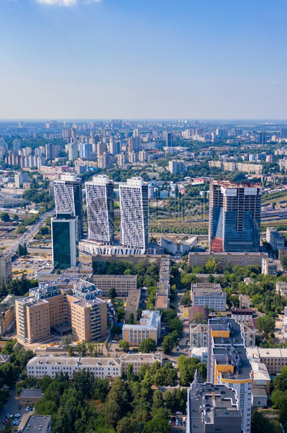 地平线基辅住宅区的空中摄影以住宅区绿色公园和在建的新摩天大楼城市摄影垂直图像复制空间中摄影城市住宅区和绿色公园在夏季蓝阴霾和阳光图片