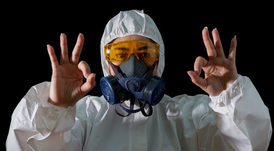 身着化学防护服和毒面具的亚洲妇女OK手签带有眼镜黑色背景安全西装女科学家安全感染概念等化学品保护服装和防气面具流行病医生预防图片