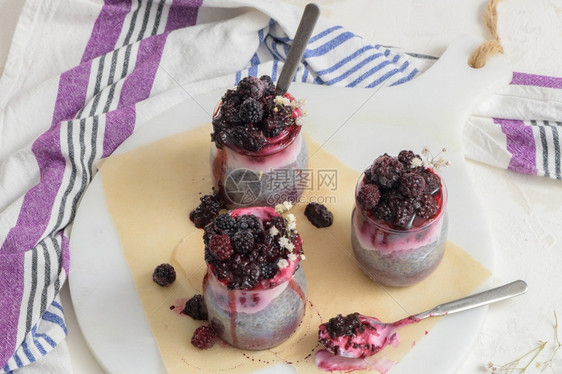 加黑莓的Chia布丁在白桌上的玻璃罐中三块种子一顿饭酸奶图片