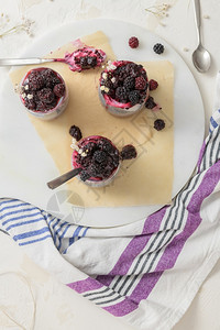 食物素主义者木板加黑莓的Chia布丁在白桌上的玻璃罐中三块图片
