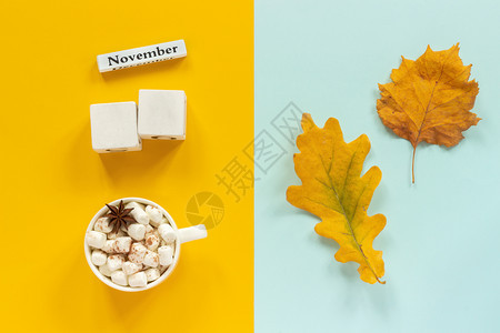 秋季作文空白木制色立方体模型和1月为您的日历数据一杯可与棉花糖和黄色秋叶蓝背景顶视图平躺模型秋季组合空白木制色立方体模型和月为您图片