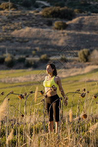 单身的积极赛跑者穿着运动服的黑发女人在乡村锻炼时做伸展运动穿着服的黑发女人在锻炼时做伸展运动图片