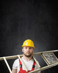 笨的建筑工人站在梯子上着一个像手持梯子的笨工人一样头盔复制空间服务图片