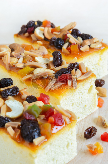 喜庆的烘烤三块水果蛋糕配有实和腰的三片饼在木制板上糖浆图片