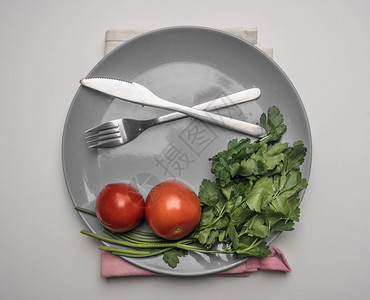 颜色夏天简单食物番茄鹦鹉和薄面糊放在餐巾纸上的灰色盘子排在白色背景上顶视面图片