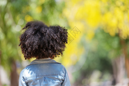 护发素模型在户外站着背她在外边的卷毛头发女孩匿名的图片