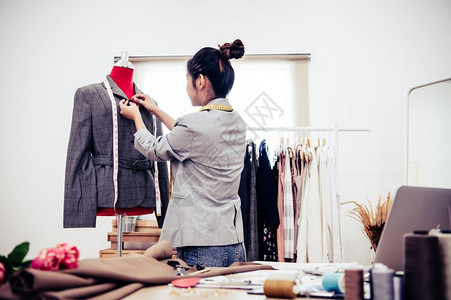 织物亚洲女时装设计师亚洲女时装设计师穿着模特服装穿正式西的制服时设计师表演室缝衣和裁概念套装假的图片