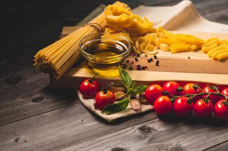 新鲜复制的烹饪用番茄奶酪干面食橄榄油fettucenne和木制棕色桌边的烤肉意大利菜自制方食谱美品图片