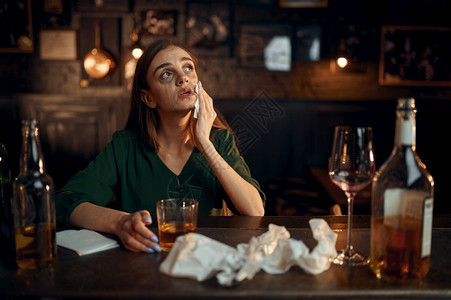 华丽的派对淑女醉酒抑郁的人在吧柜台喝精饮料吧里的一个女人类的情感休闲活动夜生酒吧柜台的醉抑郁女人图片