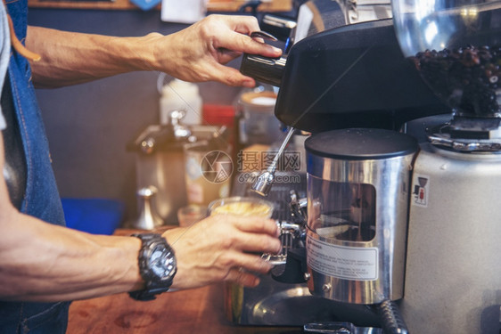 在意大利咖啡店厅里加牛奶的咖啡杯Cappuccucino紧握着咖啡馆的手机为客户自助餐厅制作棕色拿铁艺术茶采用喝图片