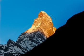 晴天高山金色阳光照耀在瑞士泽尔马蒂的特霍山峰上顶图片