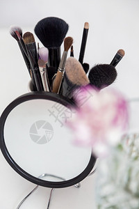 艺术美丽的化妆品不同项目用镜子和花的化妆品明亮墨水图片