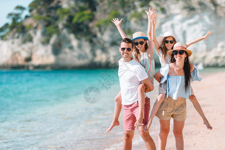 绿松石父母给孩子搭便车在海滩上骑马度假的年轻家庭玩得很开心横幅阳光图片