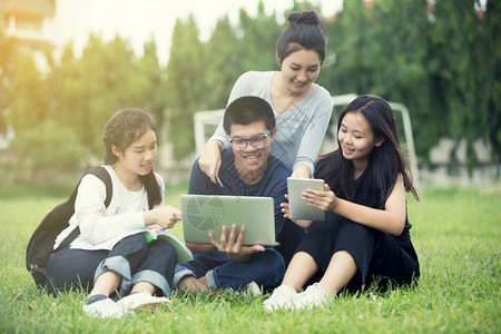 坐在草坪上一起学习的学生团体图片