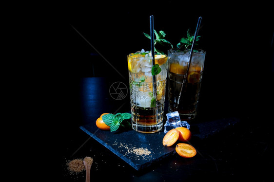 朗姆酒两杯多彩的夏季饮料黑桌上有薄荷和库姆奎特水鸡尾酒图片