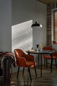 真实的简单酒店时髦阁式餐厅区有黑色木制桌和红扶臂椅窗外阳光照亮的清晨通过百叶窗复古风格照亮餐厅区图片
