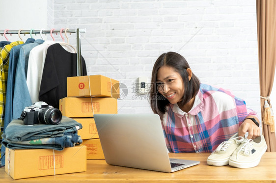 亚洲从事笔记本电脑在线售鞋工作的亚洲妇女开始创办小企业所有者电子商务思想概念电子商业女包裹士图片