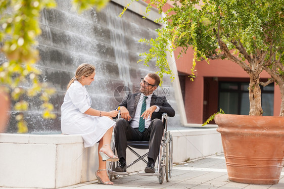 女医生与轮椅商人交谈的照片该卫生保健人们工图片