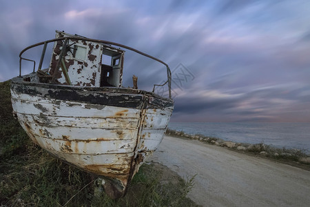 老的一只废弃木头渔船在海滩上天空令人惊叹三分之二云图片
