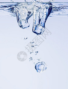 运动鸡尾酒冰的立方体在清澈水中坠落有泡新鲜的背景图片