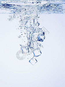 冰的立方体在清澈水中坠落有泡降低溅冷藏背景图片
