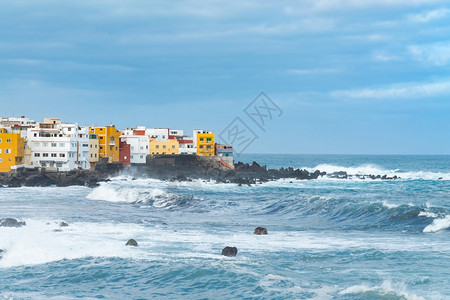 风景优美西班牙加那利群岛特内里费蓬塔布拉瓦的海岸和岩石上色彩缤纷的建筑镇支撑图片