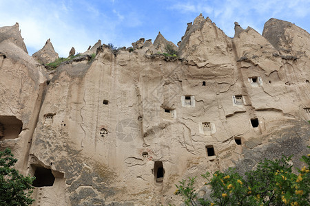 古老城的多层洞穴在开阔蓝天下的红沙岩在卡帕多西亚河山红色谷卡帕多里亚层居民洞穴里卡帕多西亚山地历史家乡村的图片