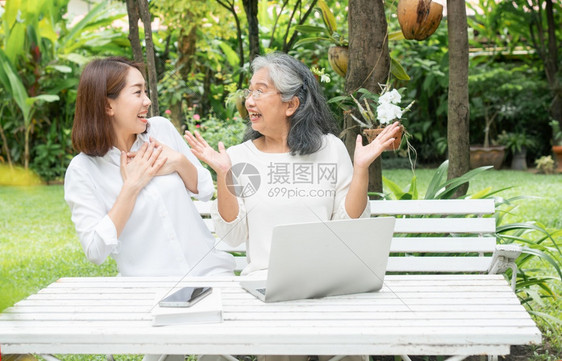 快速地退休后学习技术概念和老年人适应改造亚洲女儿教育年长妇使用计算机笔记本电脑手提在线社交媒体教授年长老妇女的亚洲儿简单老图片