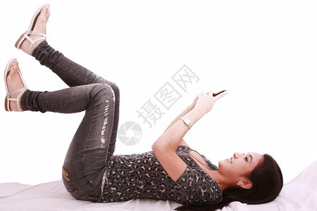技术巴拿马美丽的年轻女孩躺在枕头上手机聊天愉快图片