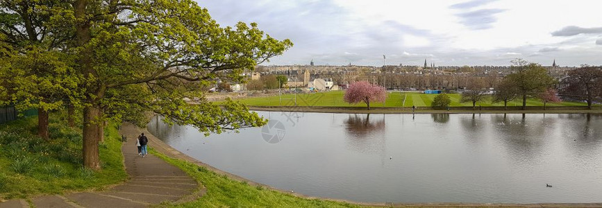 首都一种对夫妇在苏格兰爱丁堡因弗勒莱特公园的池塘中漫步于春下午部分阴云四伏步行图片