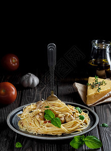 帕尔马干酪卡罗尼带奶酪蘑菇和蔬菜位于黑暗木质背景上面条和意大利粘在盘子上的叉近浅田地深处素食午餐的概念营养美食图片