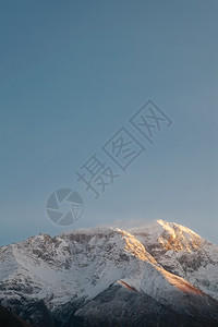 巴基斯坦GilgitBaltistanHunzaNagar山谷的清蓝天空日落时对卡拉科姆山脉雪盖峰的垂直自然景观视图极简主义者蓝图片