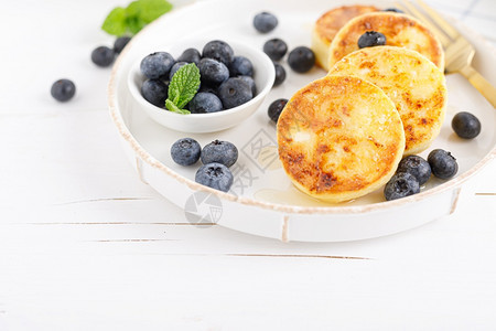 烹饪配有蜂蜜和新鲜蓝莓健康饮食品早餐的干酪或卷饼吃菜单图片