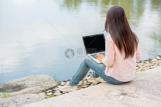 会议在公共园户外工作在笔记本电脑室外工作对坐在公园里做笔记本的女进行笔记本工作的图像剪裁成美丽的年轻图片