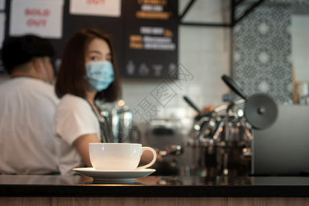 店铺普通的咖啡杯选择焦点和戴面罩的亚洲女律师协会的背景防止传染疾病在咖啡店酿制从COVID预防的概念18a59职员图片
